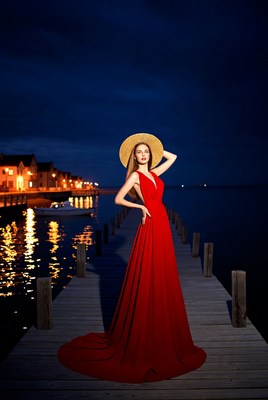 Woman in red dress on pier at night