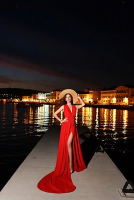Woman in red gown on dock at night