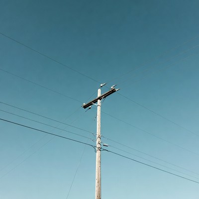 Utility Pole with Wires Against Blue Sky