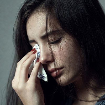 Asian woman crying with tissue