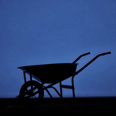 Wheelbarrow silhouette on blue background
