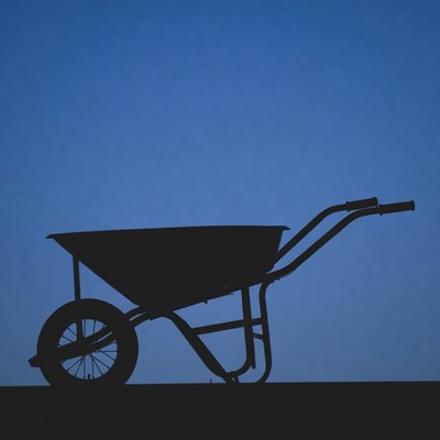 Wheelbarrow silhouette on blue background