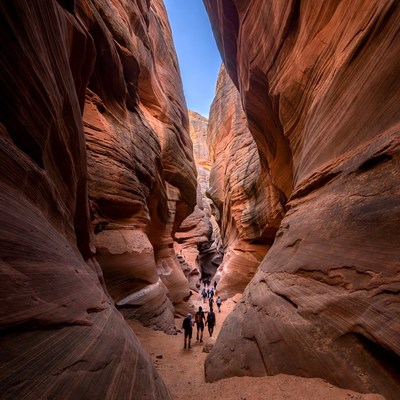 Hikers in Narrow Red Rock Slot Canyon