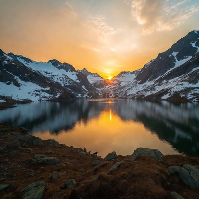 Sunset over snowy mountain lake