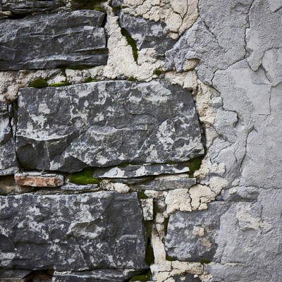 Old stone wall with moss and plaster