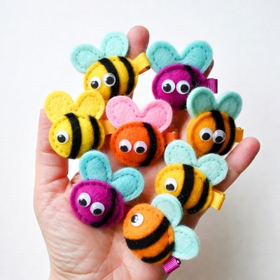 Hand holding colorful felt bee hair clips