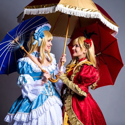 Two blonde women in Lolita dresses with parasols