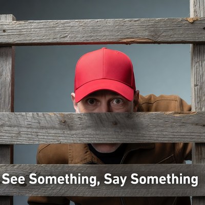 Man peeking through wooden fence