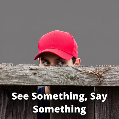 Man peeking over wooden fence