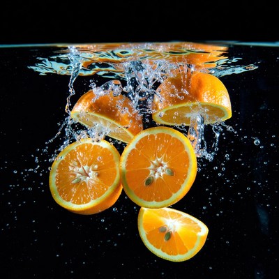 Oranges splashing in water