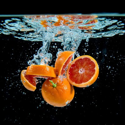 Oranges splashing in water