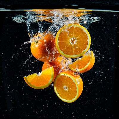 Oranges splashing in water