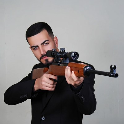 Man aiming sniper rifle in suit