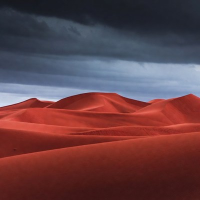 Red Sand Dunes Under Dark Storm Clouds