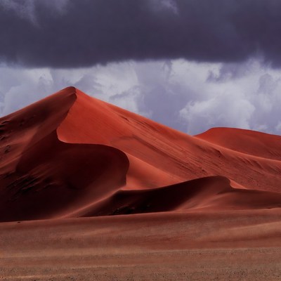 Red Sand Dunes Under Stormy Clouds