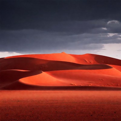 Red Sand Dunes Under Dark Clouds