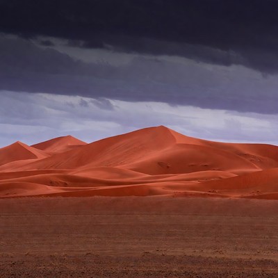 Red Sand Dunes Under Stormy Sky