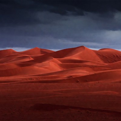 Red Sand Dunes Under Stormy Sky