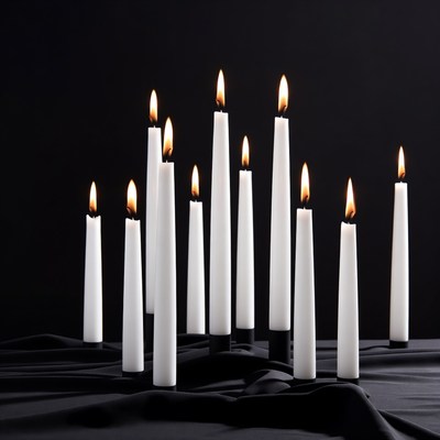 White candles burning on black background