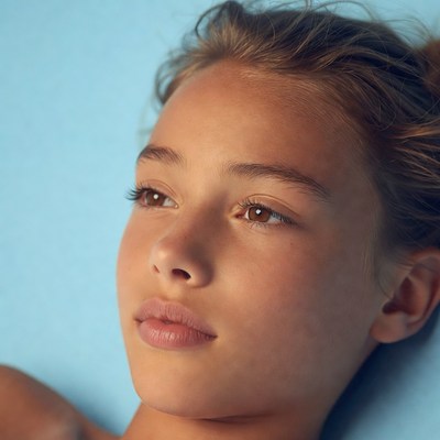 Teen girl with brown eyes on blue background