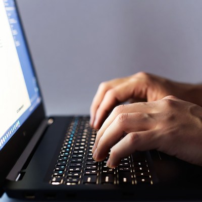 Man typing on laptop keyboard