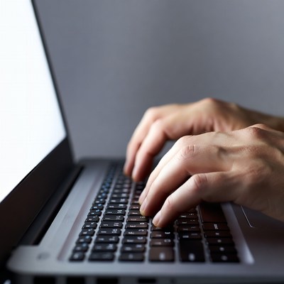Man typing on laptop keyboard