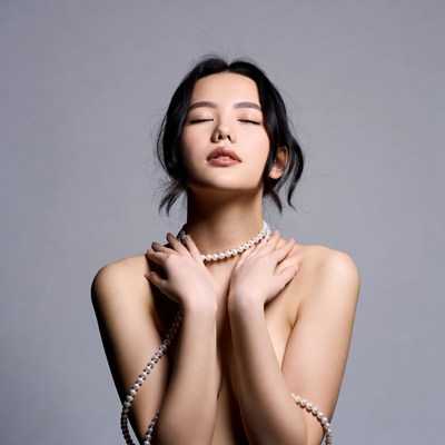 Asian woman holding pearl necklace