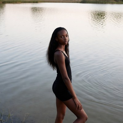 African-American woman standing by lake