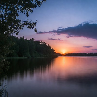 Sunset over calm lake with trees