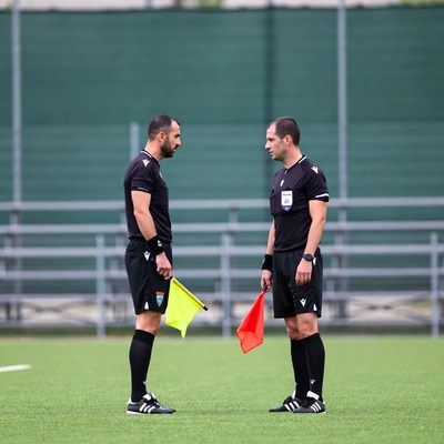 Two soccer referees holding flags