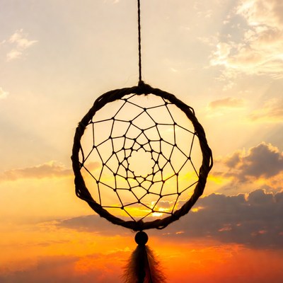 Dreamcatcher against sunset sky