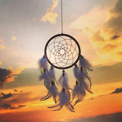 Dreamcatcher hanging against sunset sky