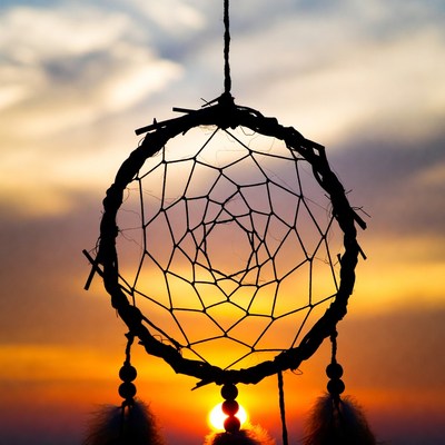Dreamcatcher against sunset sky