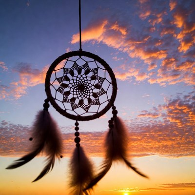 Dreamcatcher against sunset sky
