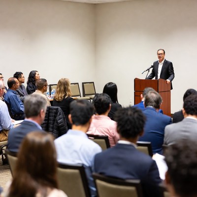 Man speaking at podium to audience