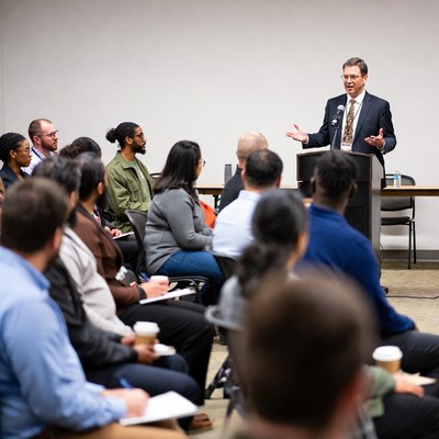 Man speaking at diverse audience seminar