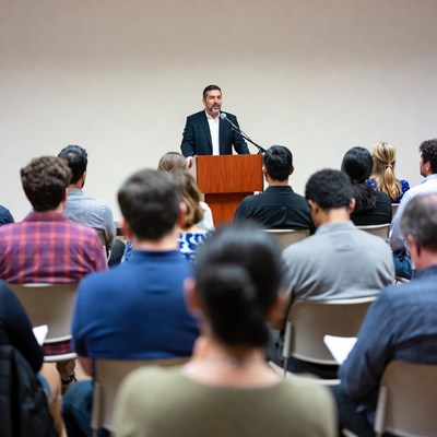 Man speaking at podium to audience
