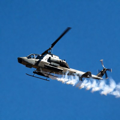 Military helicopter flying with smoke trail