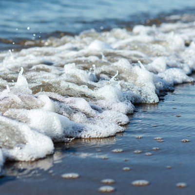 Ocean waves crashing on sandy beach