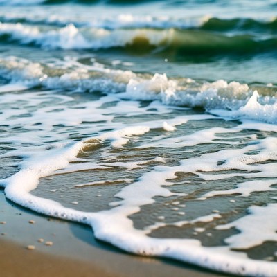 Ocean waves crashing on sandy beach