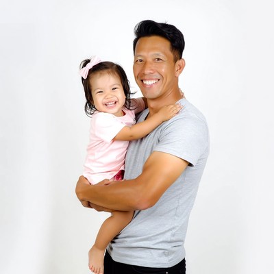 Asian father holding smiling baby girl