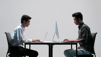 Two men working on laptops