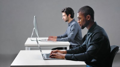 Two men working on laptops