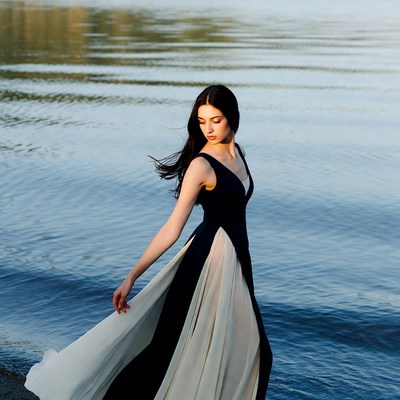 Asian woman in flowing dress by lake