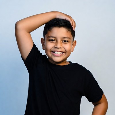 Smiling Latino boy hand on head