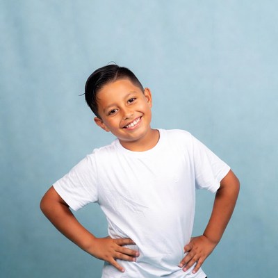 Smiling Latino boy hands on hips