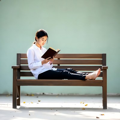 Asian girl reading book on bench