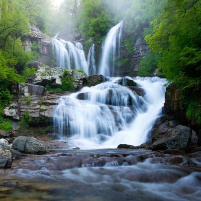 Majestic multi-tiered waterfall in lush forest