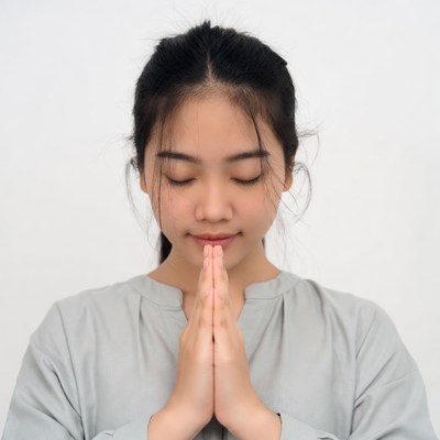 Asian girl praying with hands together