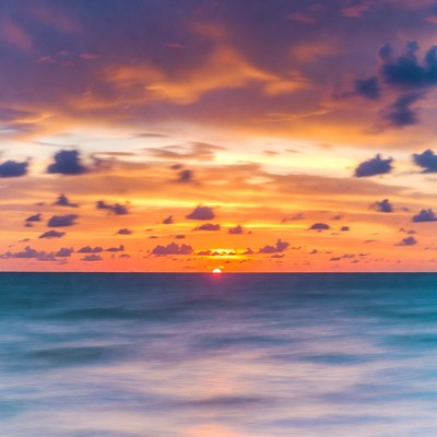 Sunset over ocean with colorful clouds